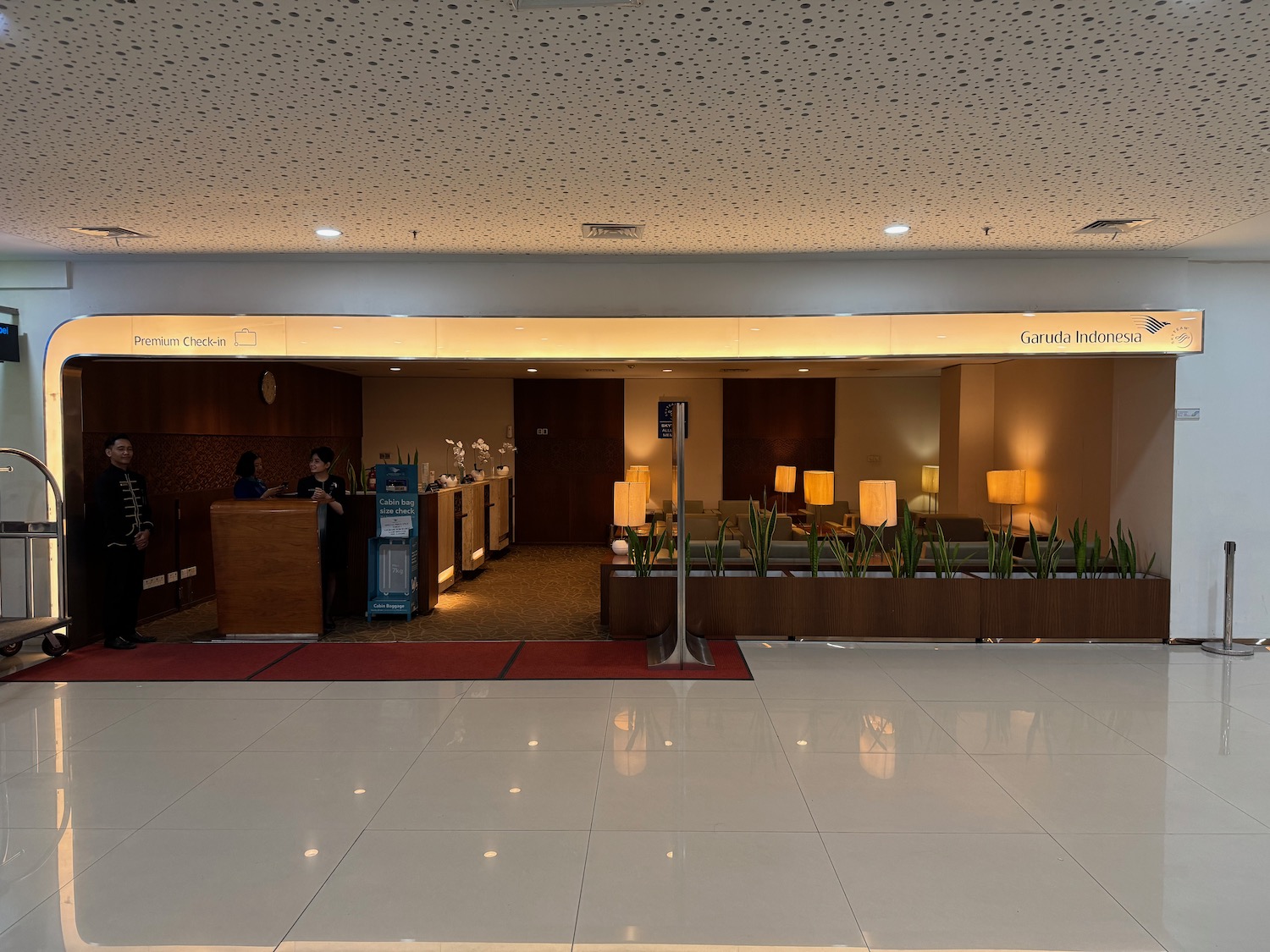 a lobby with a reception desk and a couple people standing behind it