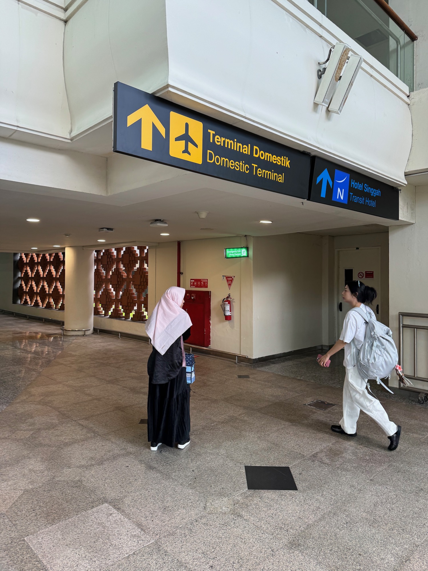 a woman walking in a building with a sign