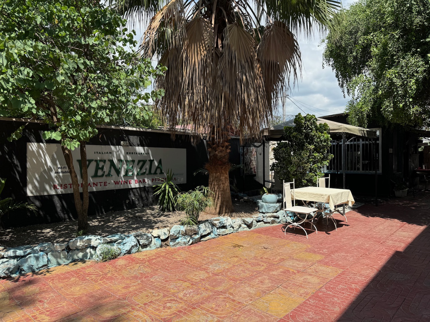 a patio with a table and chairs and a tree