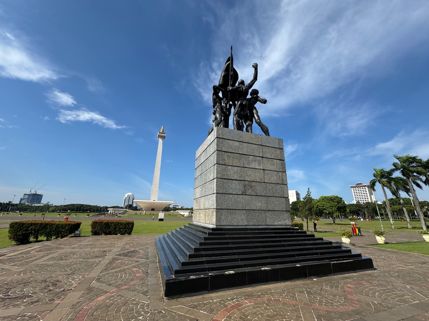 a statue of people on a pedestal in a park