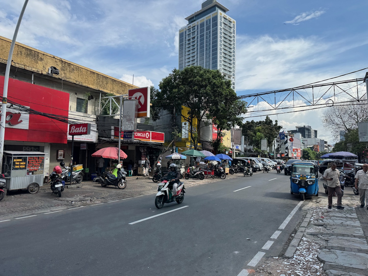 a street with motorcycles and umbrellas