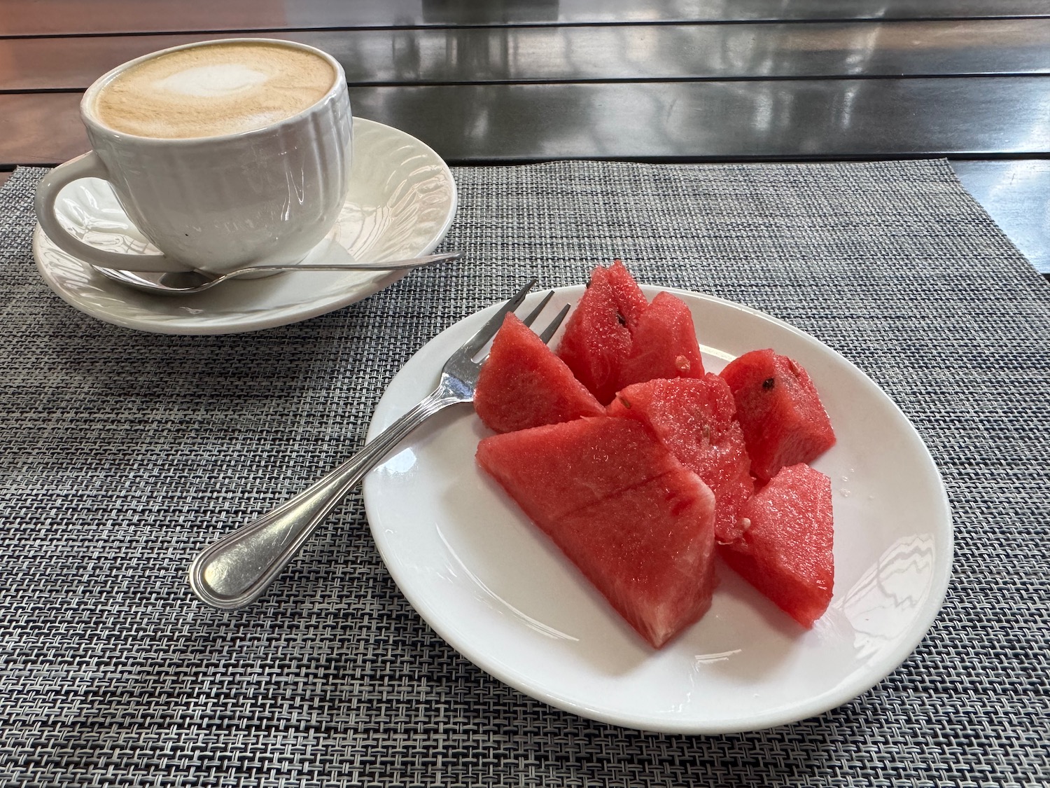 a plate of watermelon and a cup of coffee