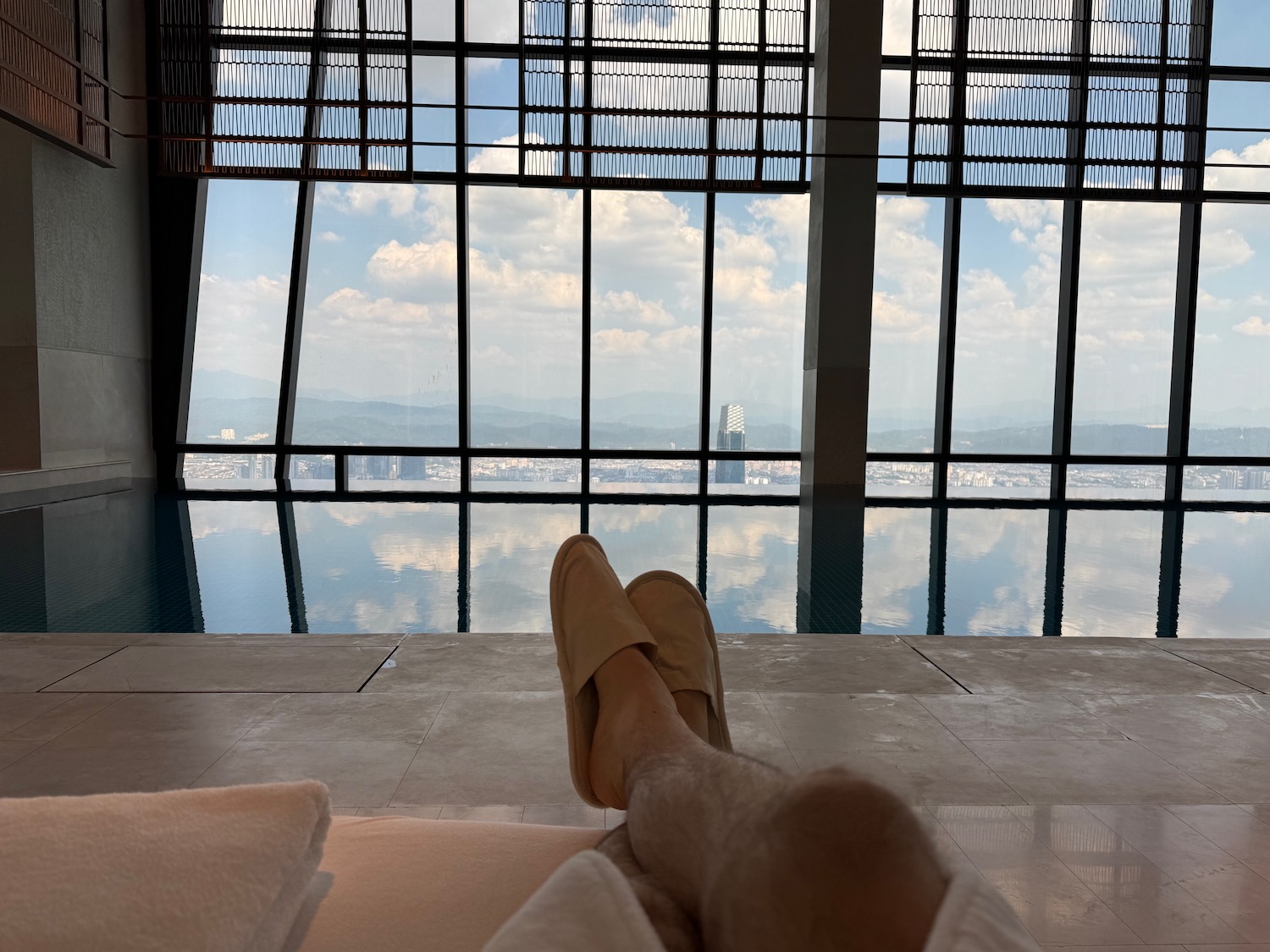 a person's legs in slippers on a bed