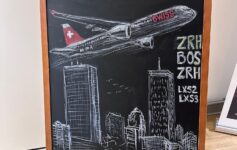 a chalkboard with a drawing of an airplane and cityscape