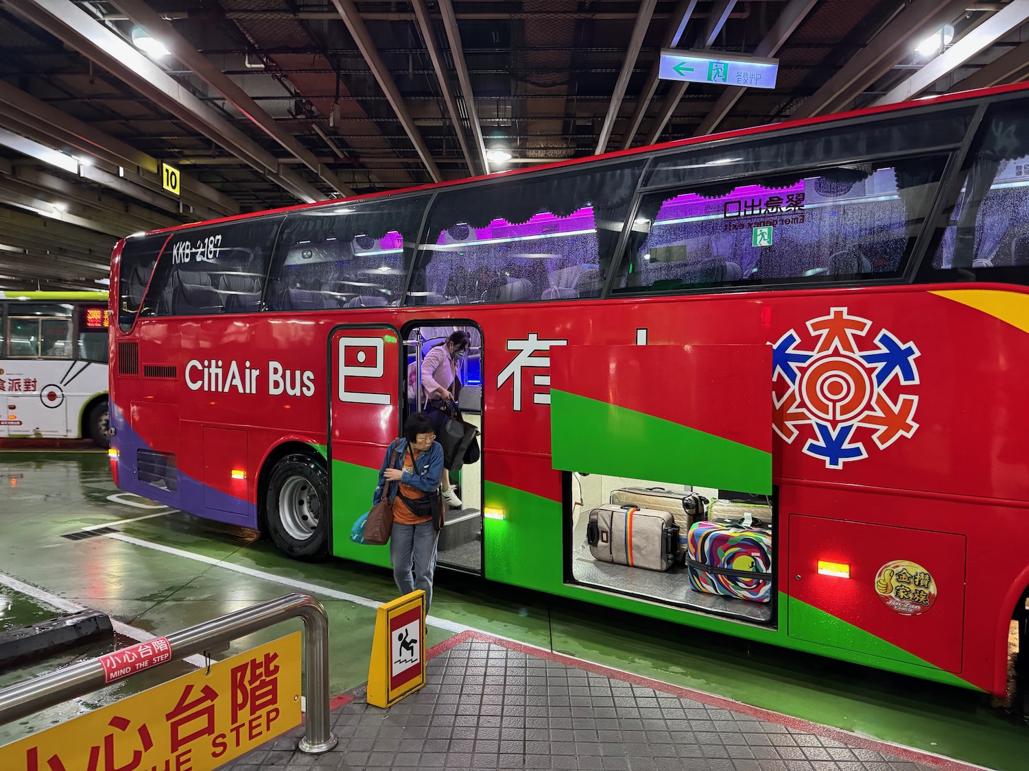 a red bus with a couple of people getting into it