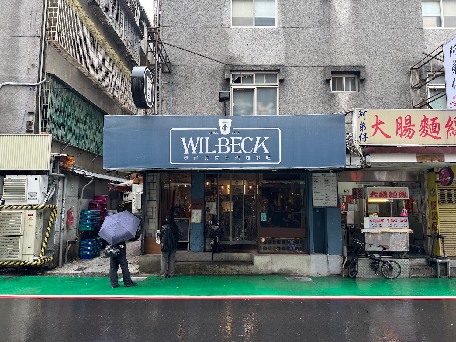 a store front with people holding umbrellas
