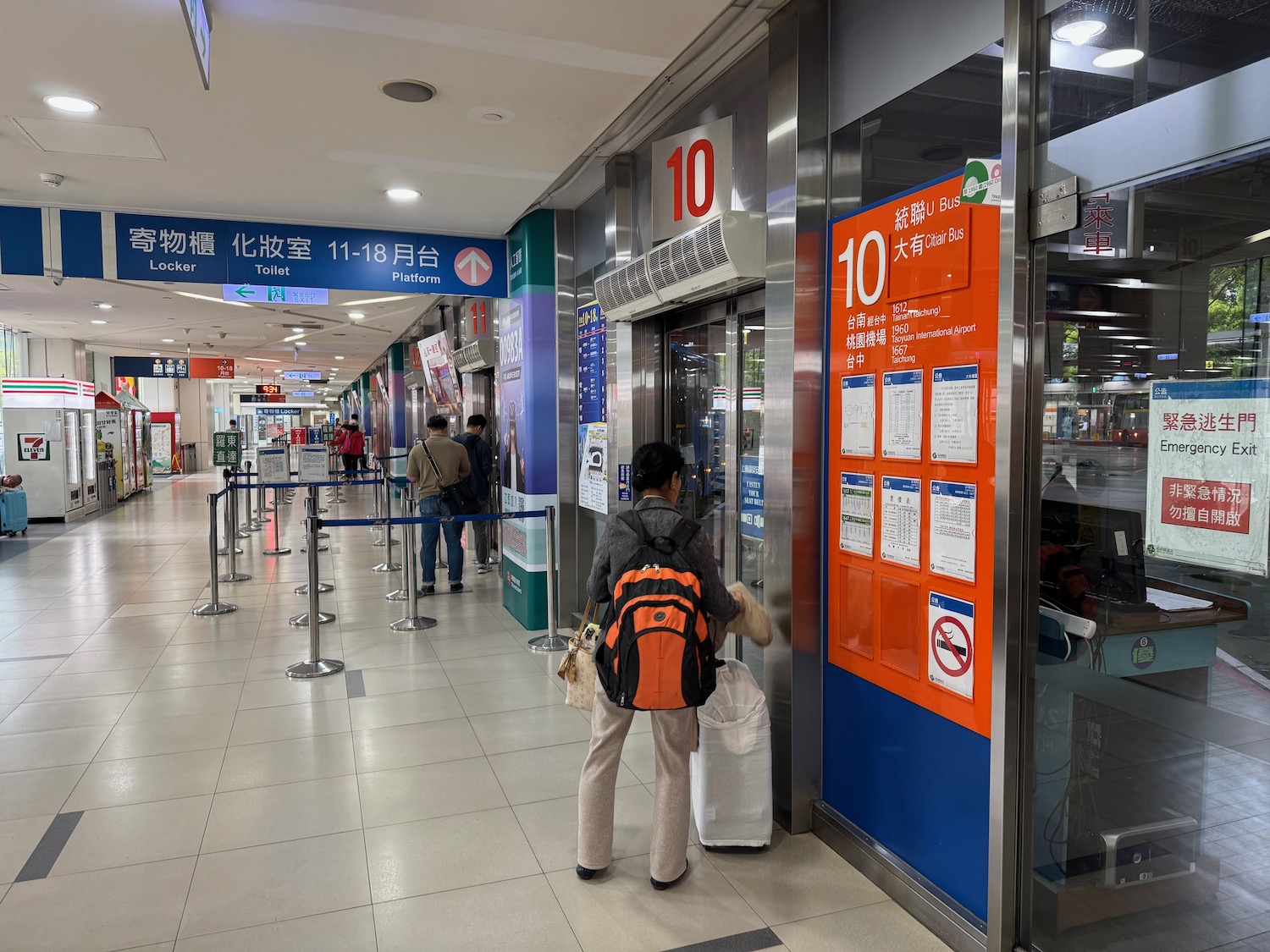 a woman standing in a hallway with a large sign