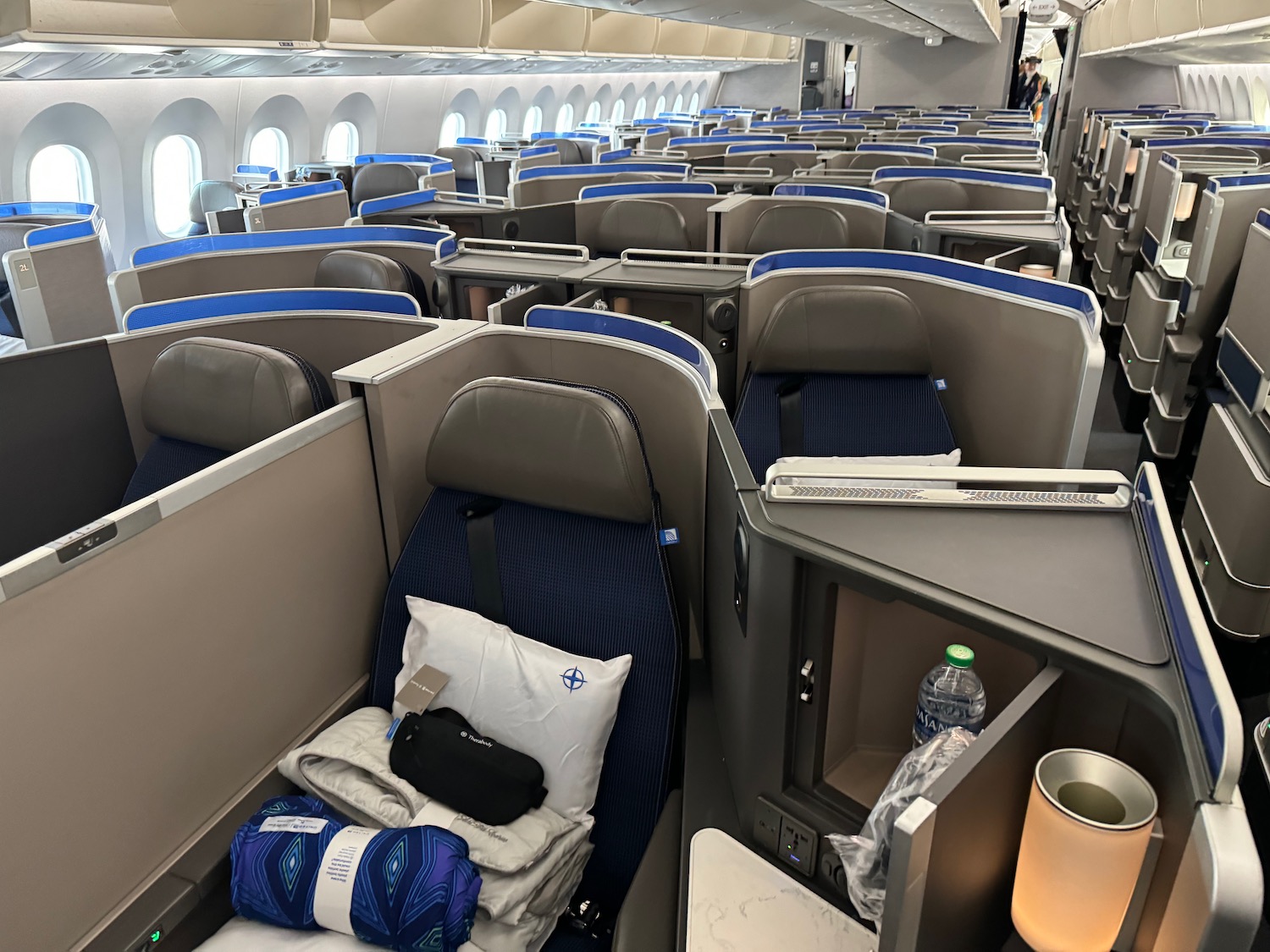 an airplane seats with blue seats and a white pillow
