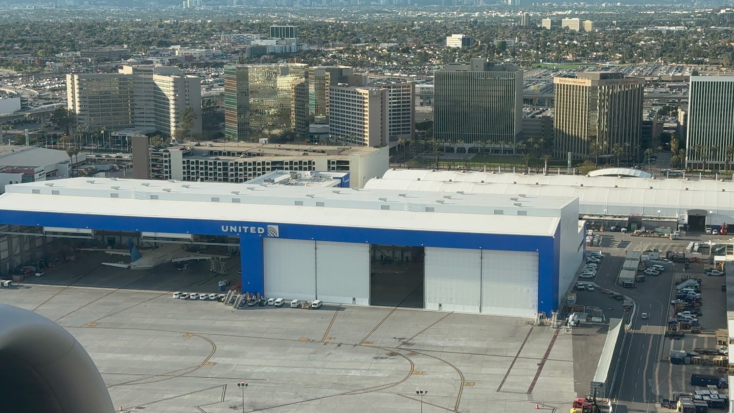 a large hangar with a city in the background