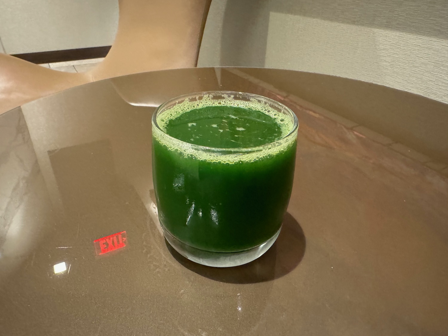 a glass of green juice on a table