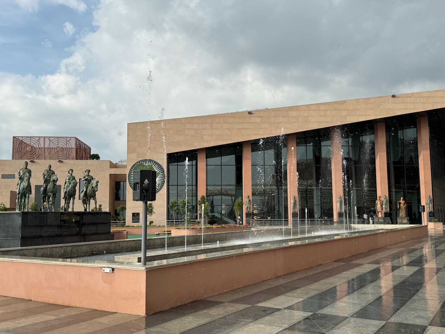 a building with a fountain and statues in the background