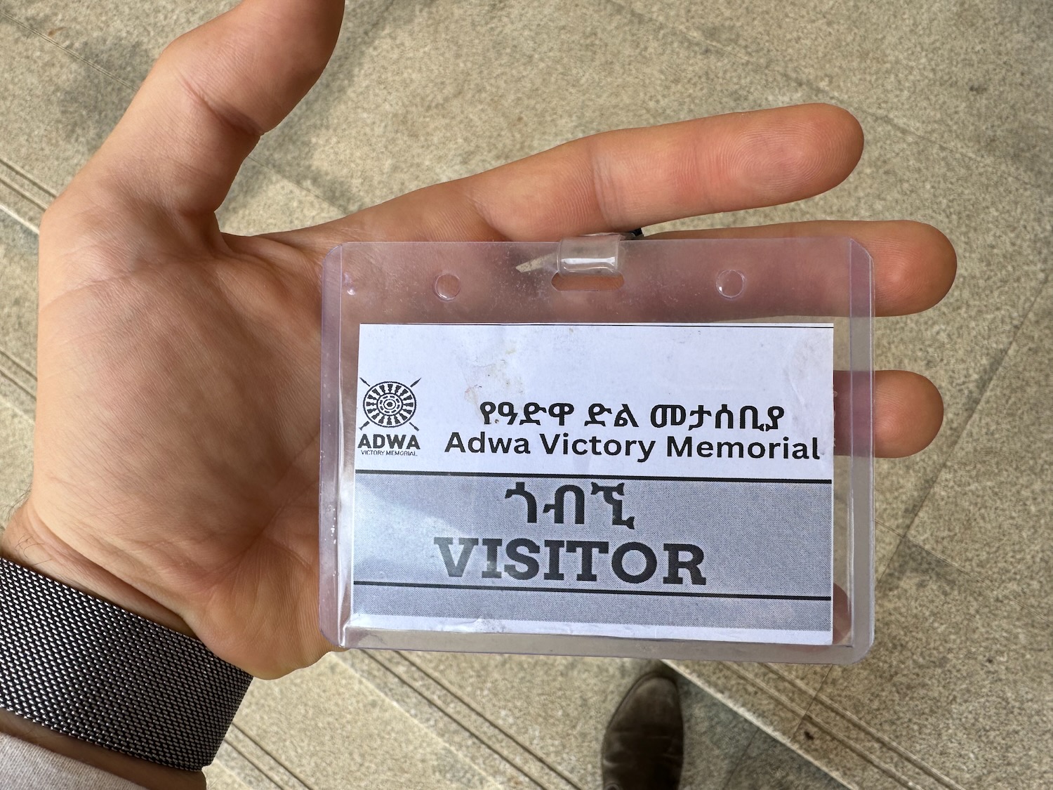 a hand holding a plastic badge