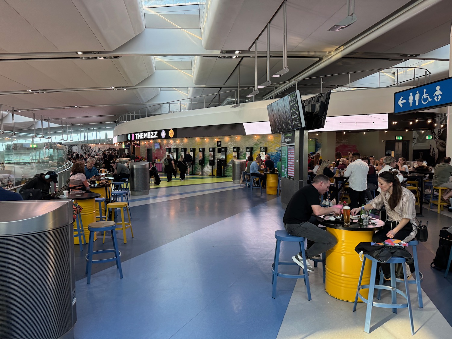 people sitting at tables in a large building