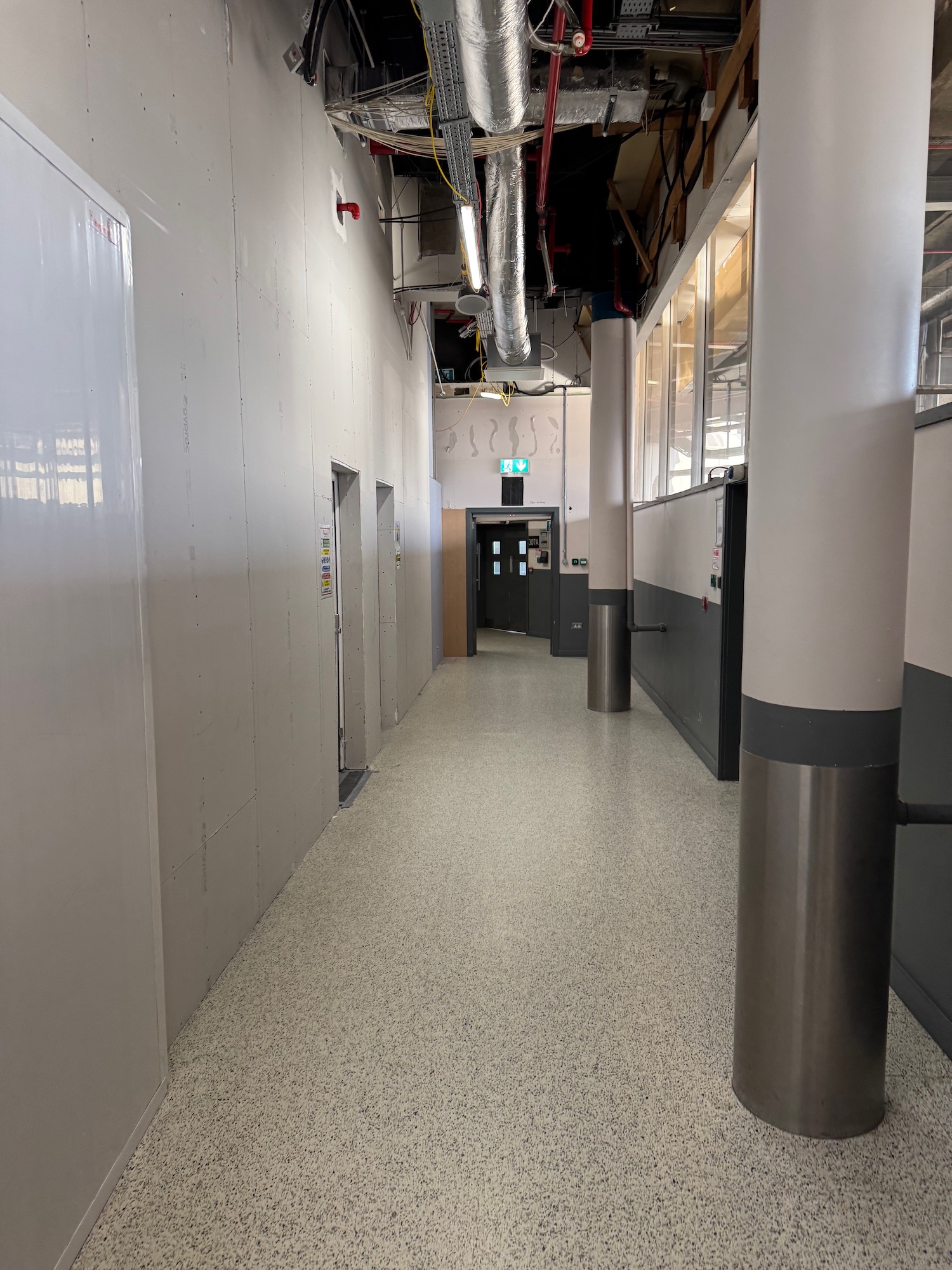 a hallway with white walls and grey columns