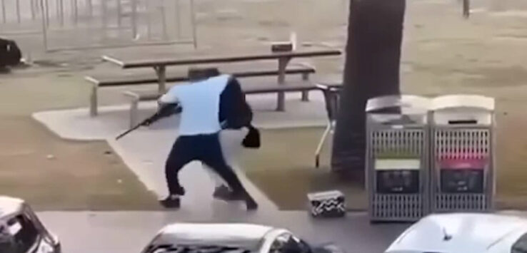 a person holding a bag and walking on a sidewalk