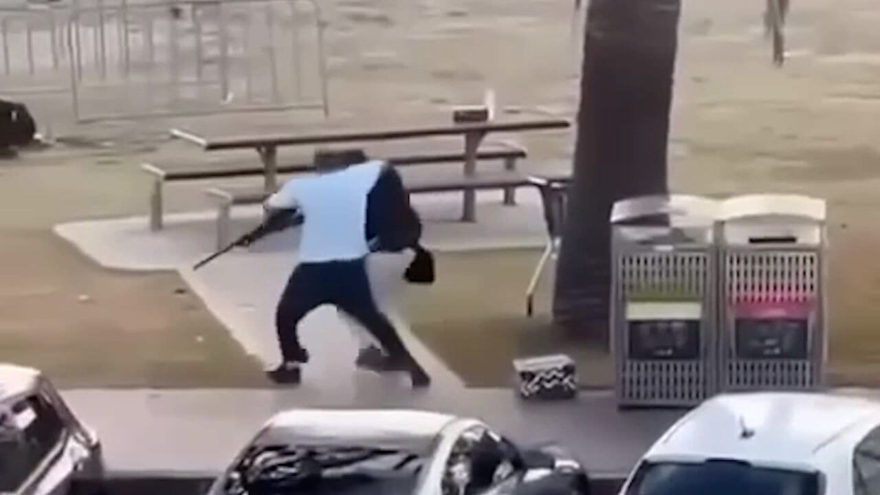 a person holding a bag and walking on a sidewalk