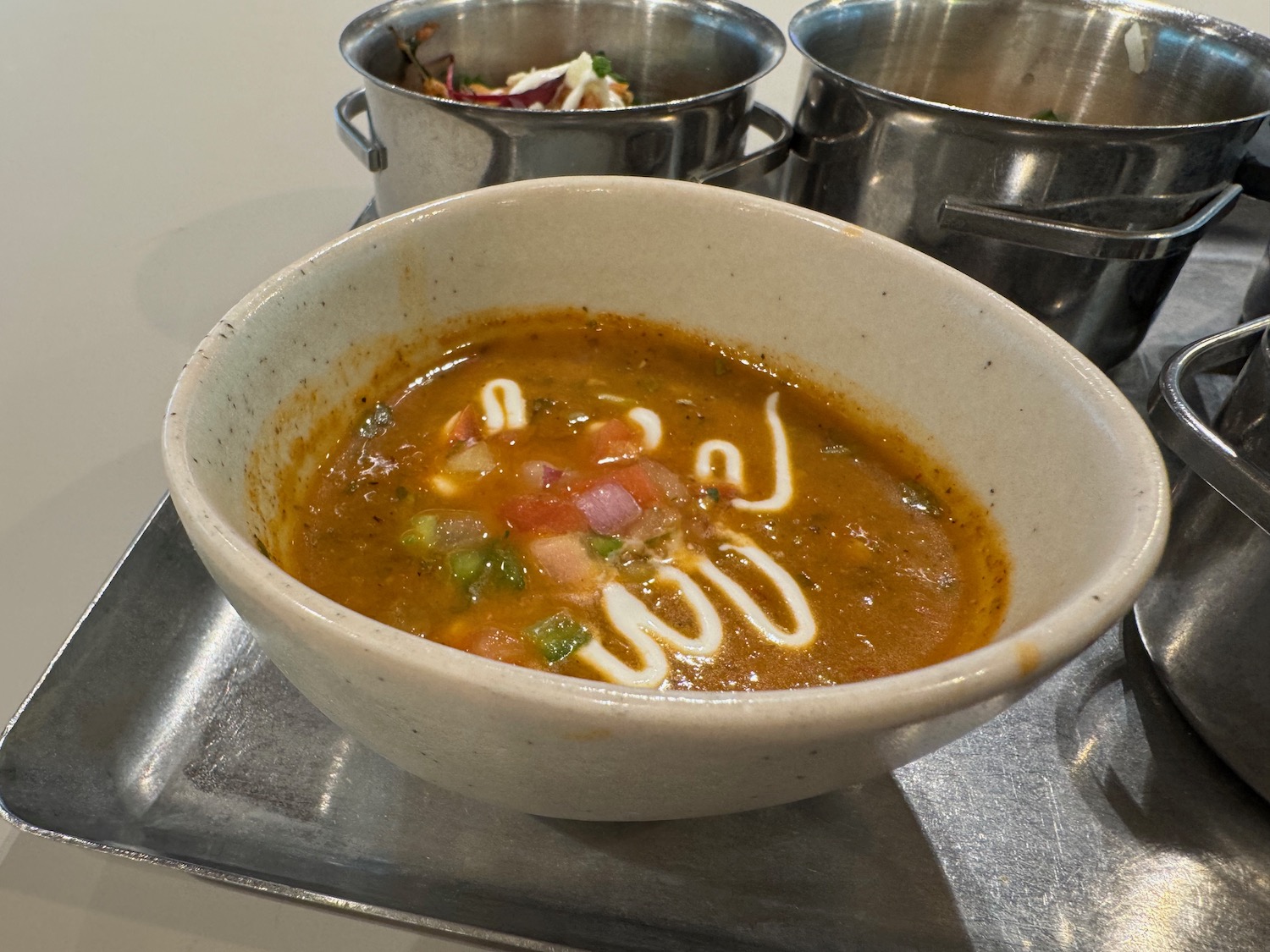 a bowl of soup with white sauce and sauce in it