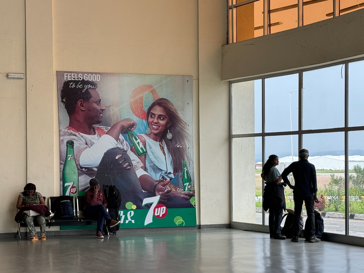a group of people standing in a large room with a poster on the wall
