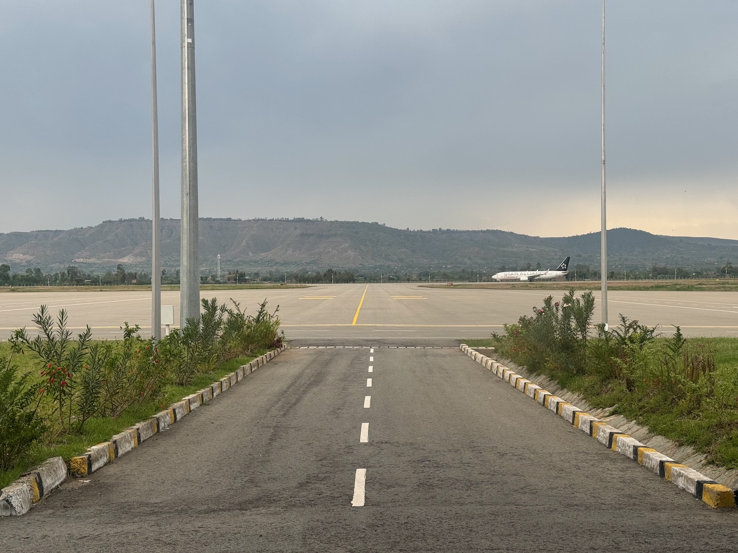 an empty runway with a plane in the background