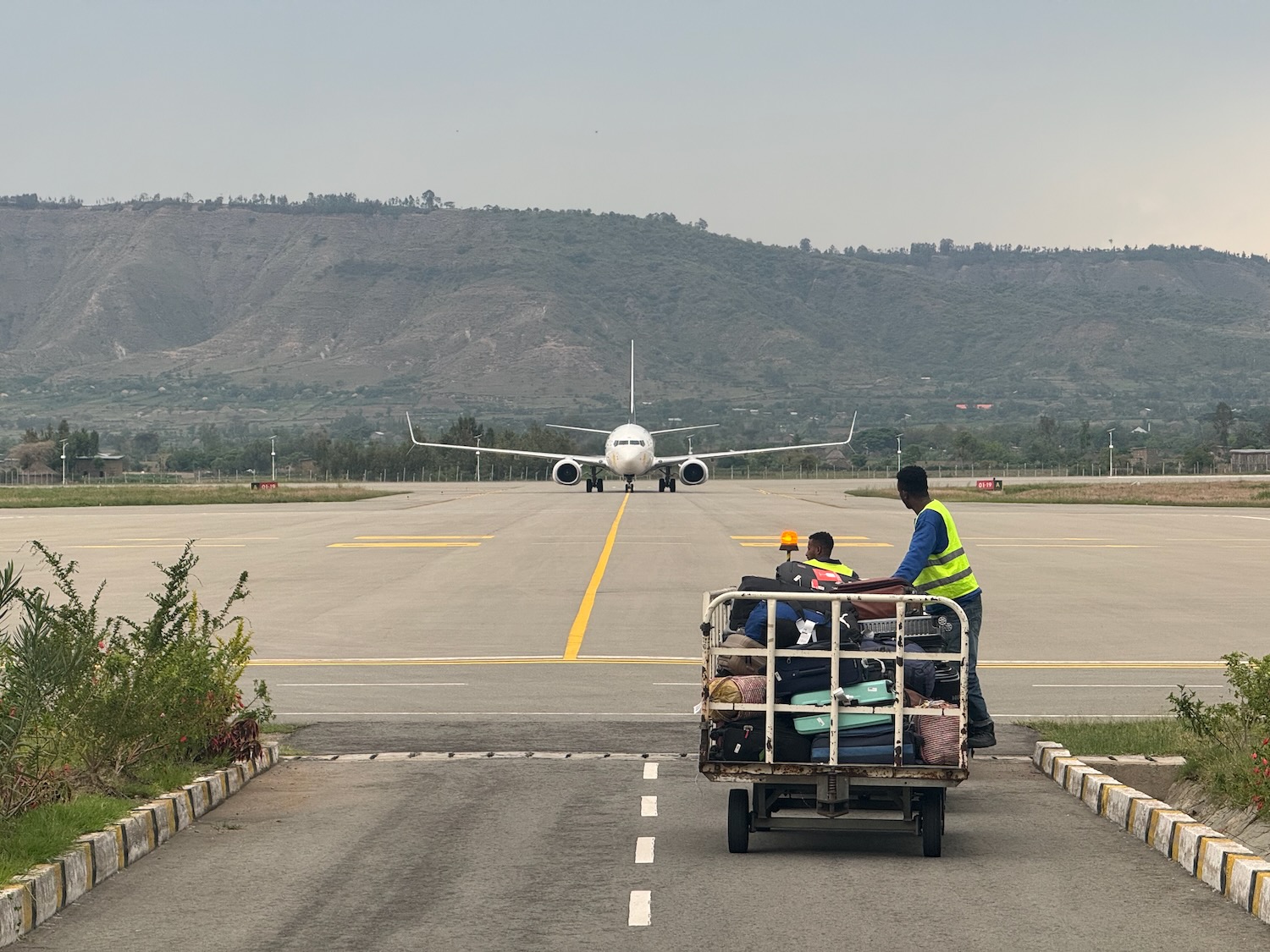 a group of people on a cart on a runway with a plane in the background