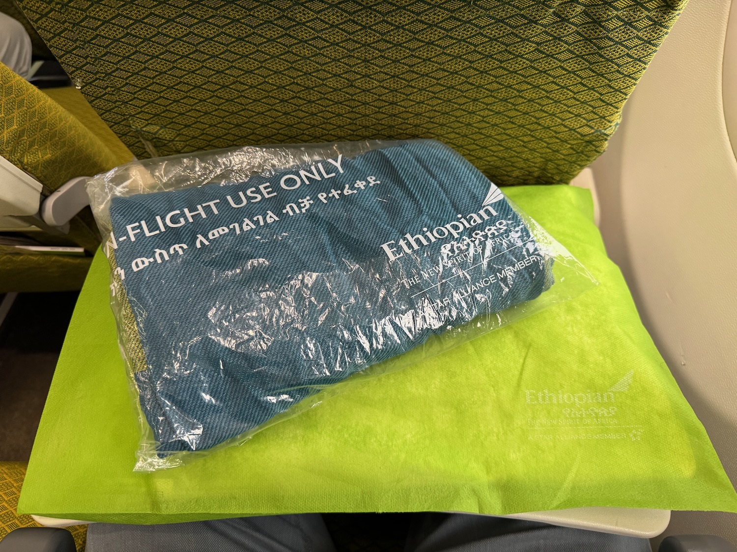 a blue towel in a plastic bag on a green cushion