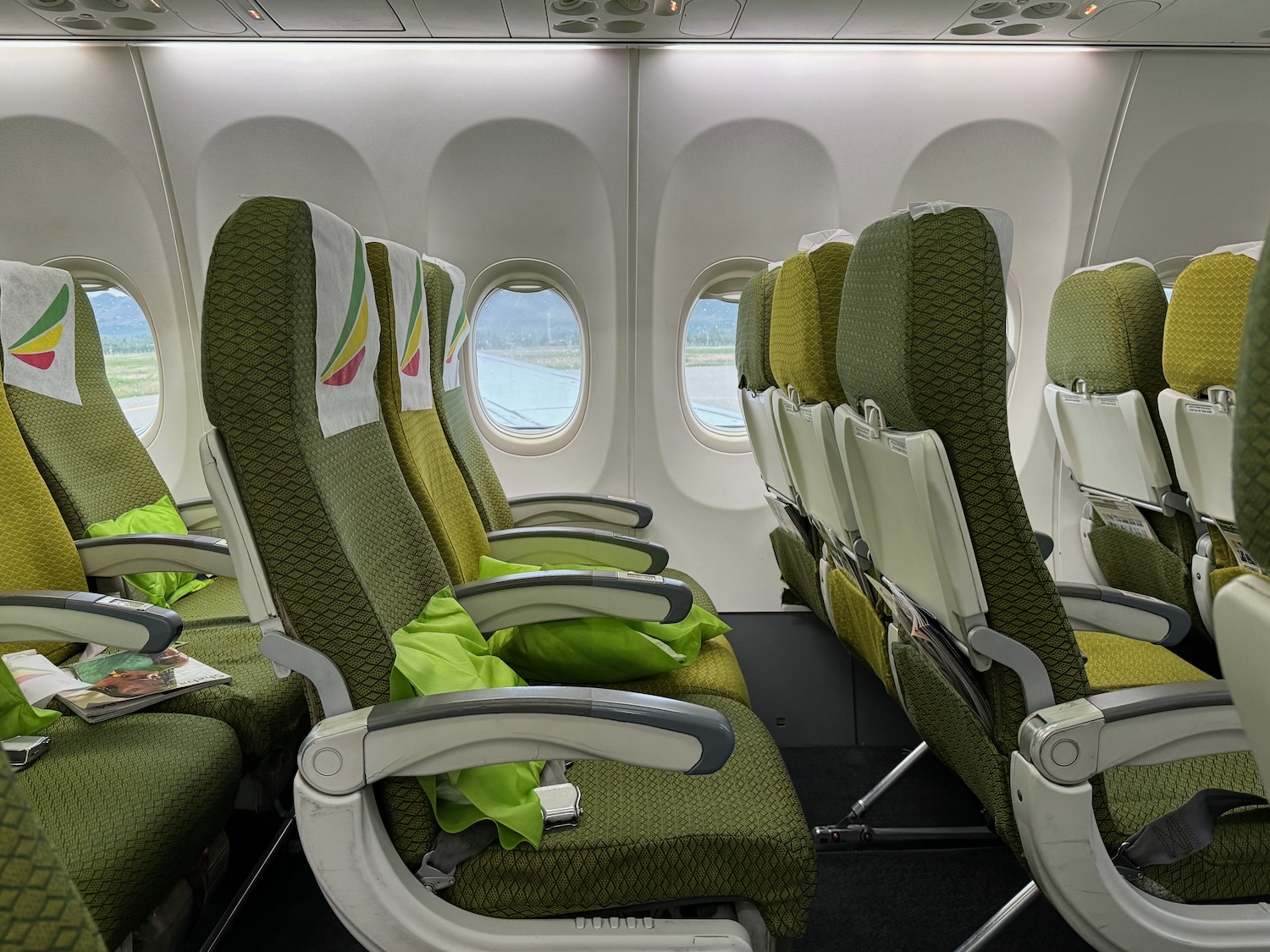 a row of green seats in an airplane