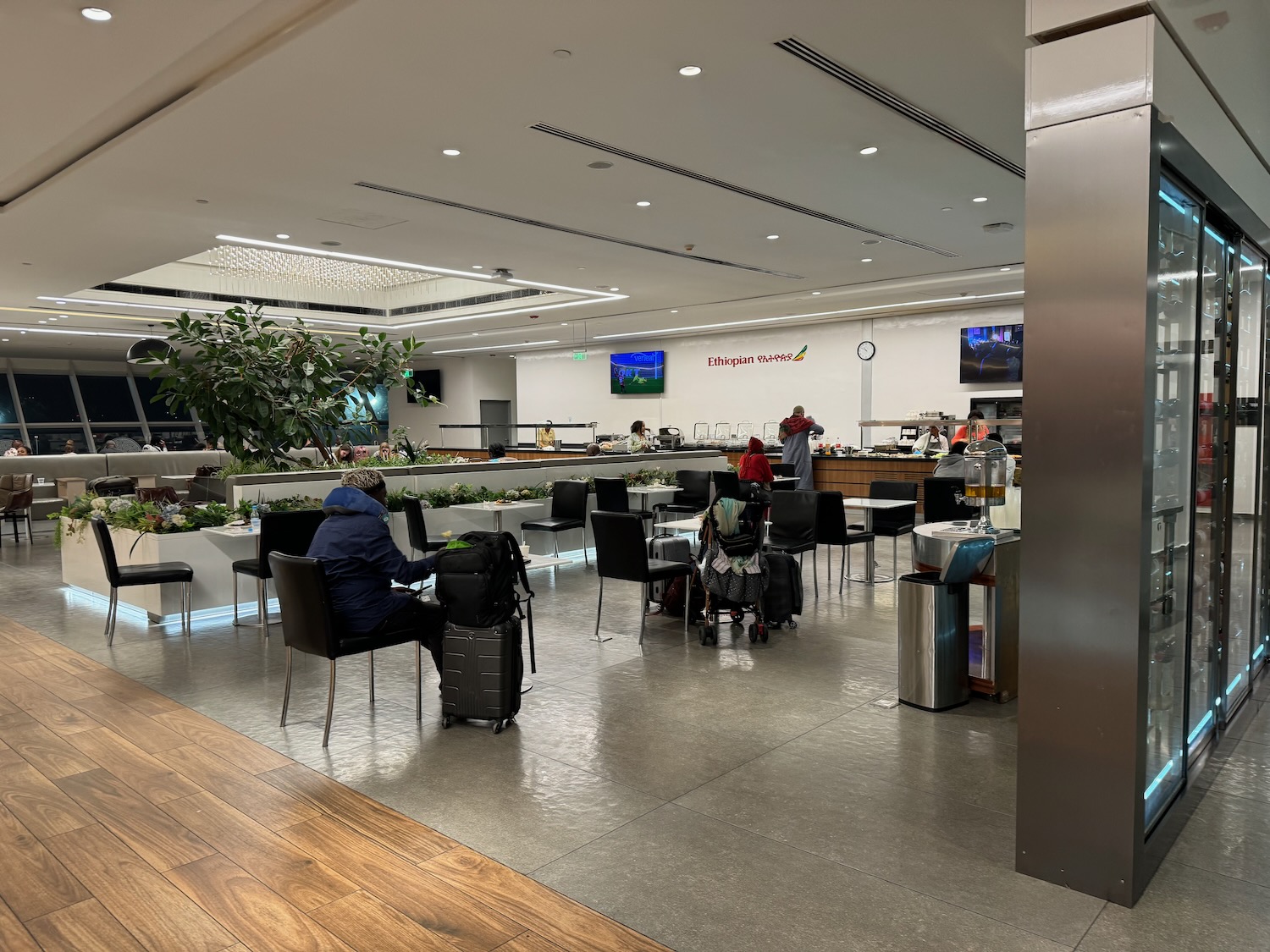 people in a restaurant with people sitting in chairs