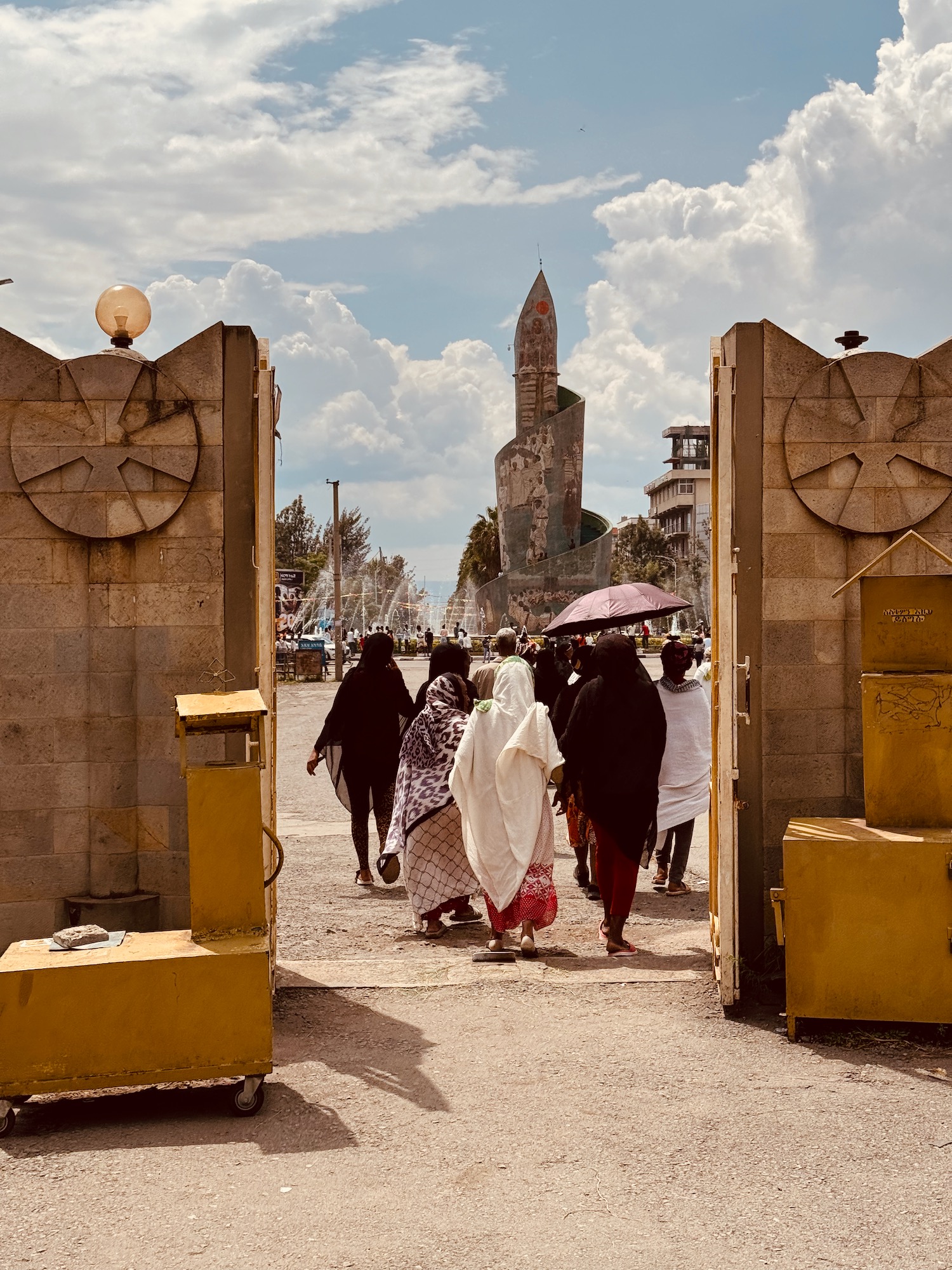 a group of people walking through a stone gate
