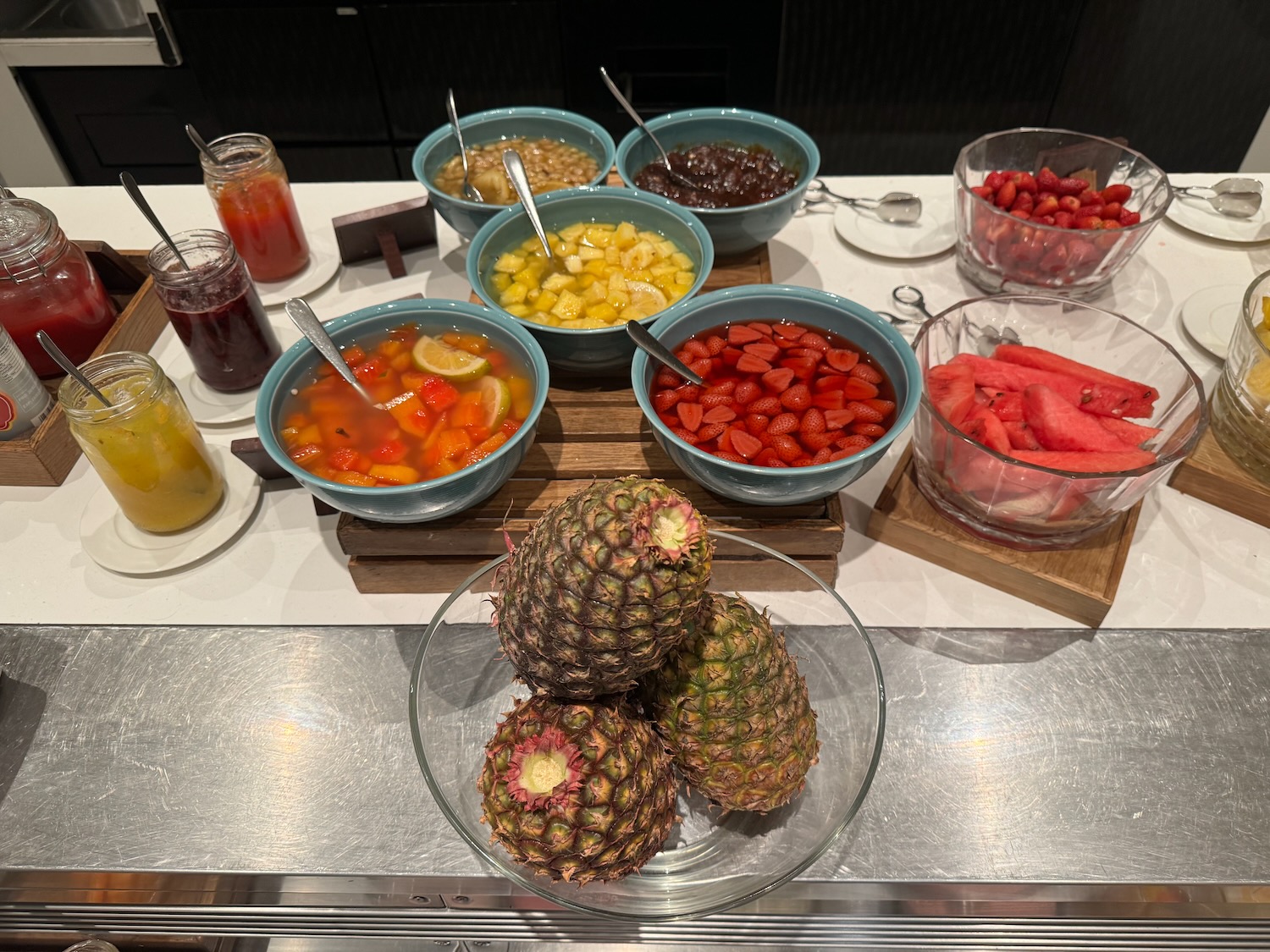 a table with bowls of fruit and jams