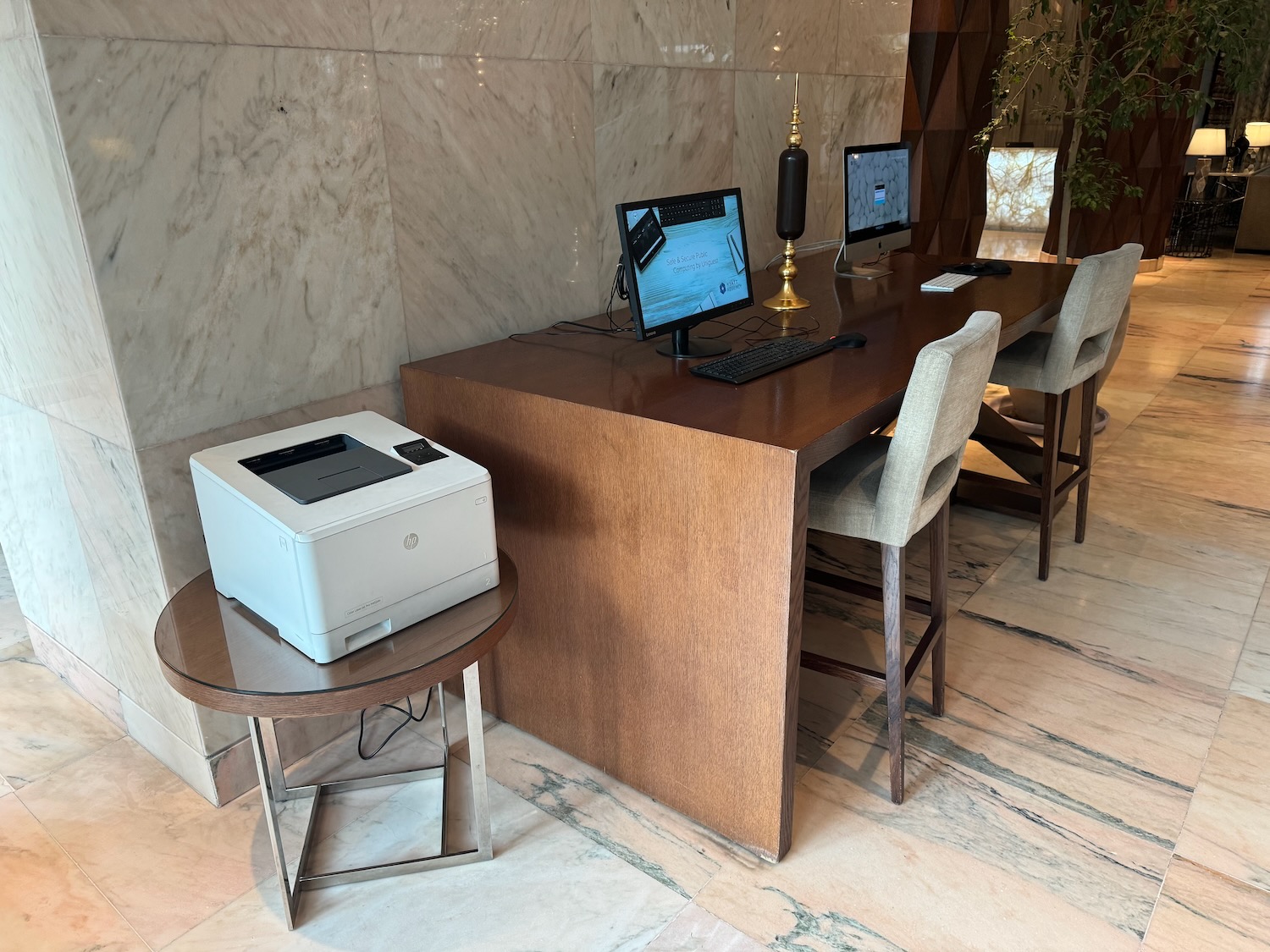 a desk with computers and a printer