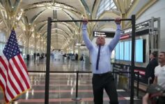 a man holding up a bar in a building