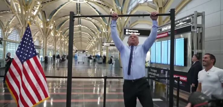 a man holding up a bar in a building