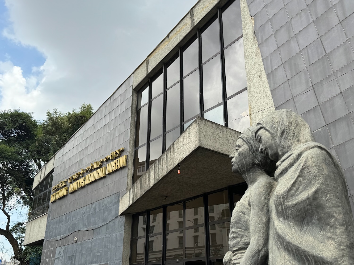 a stone statue of two people in front of a building