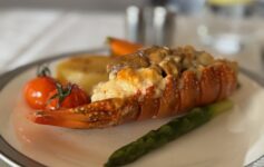 a lobster tail with vegetables on a plate