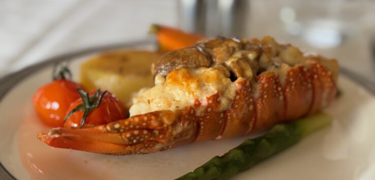 a lobster tail with vegetables on a plate