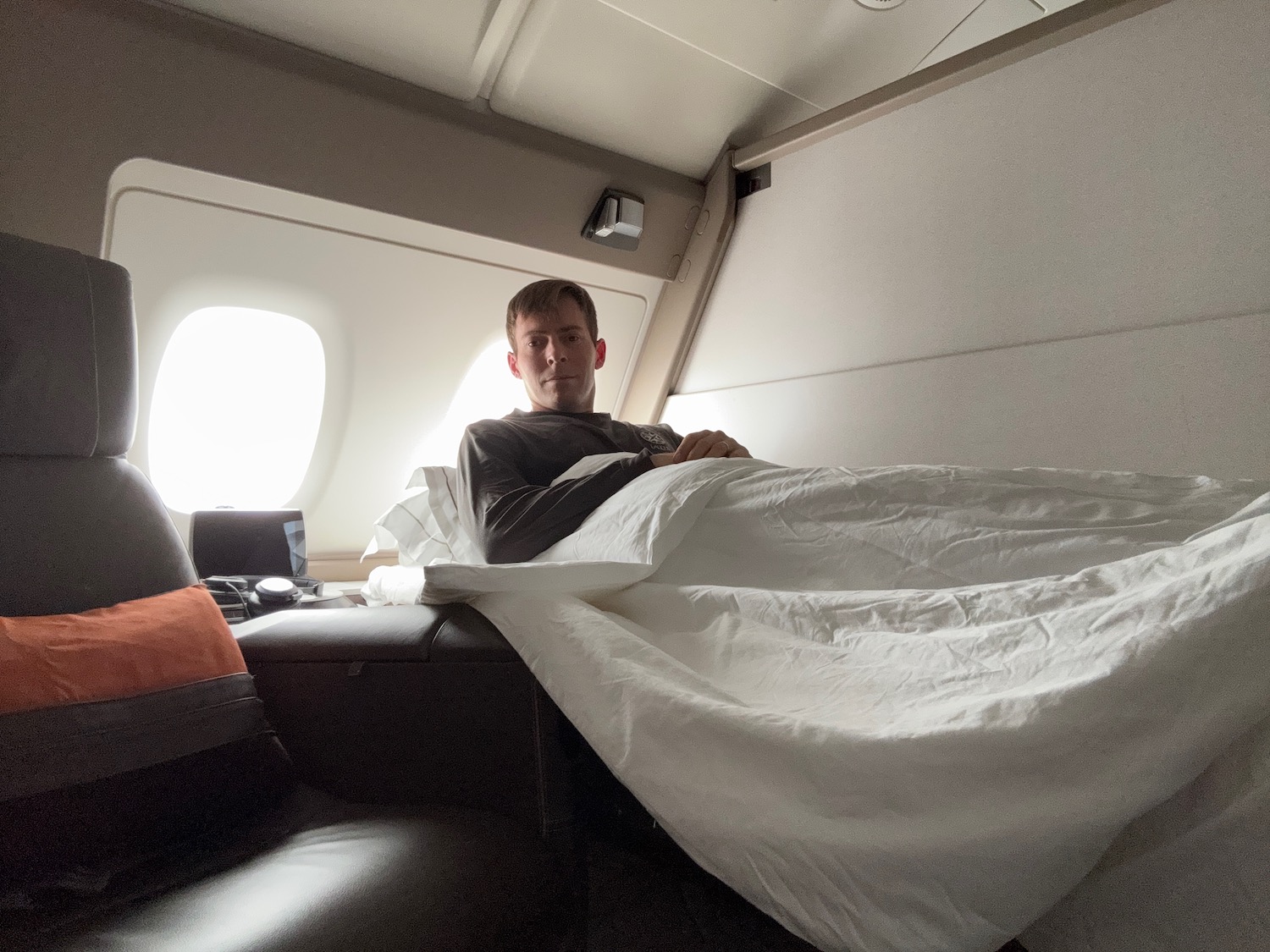 a man sitting on a bed in an airplane