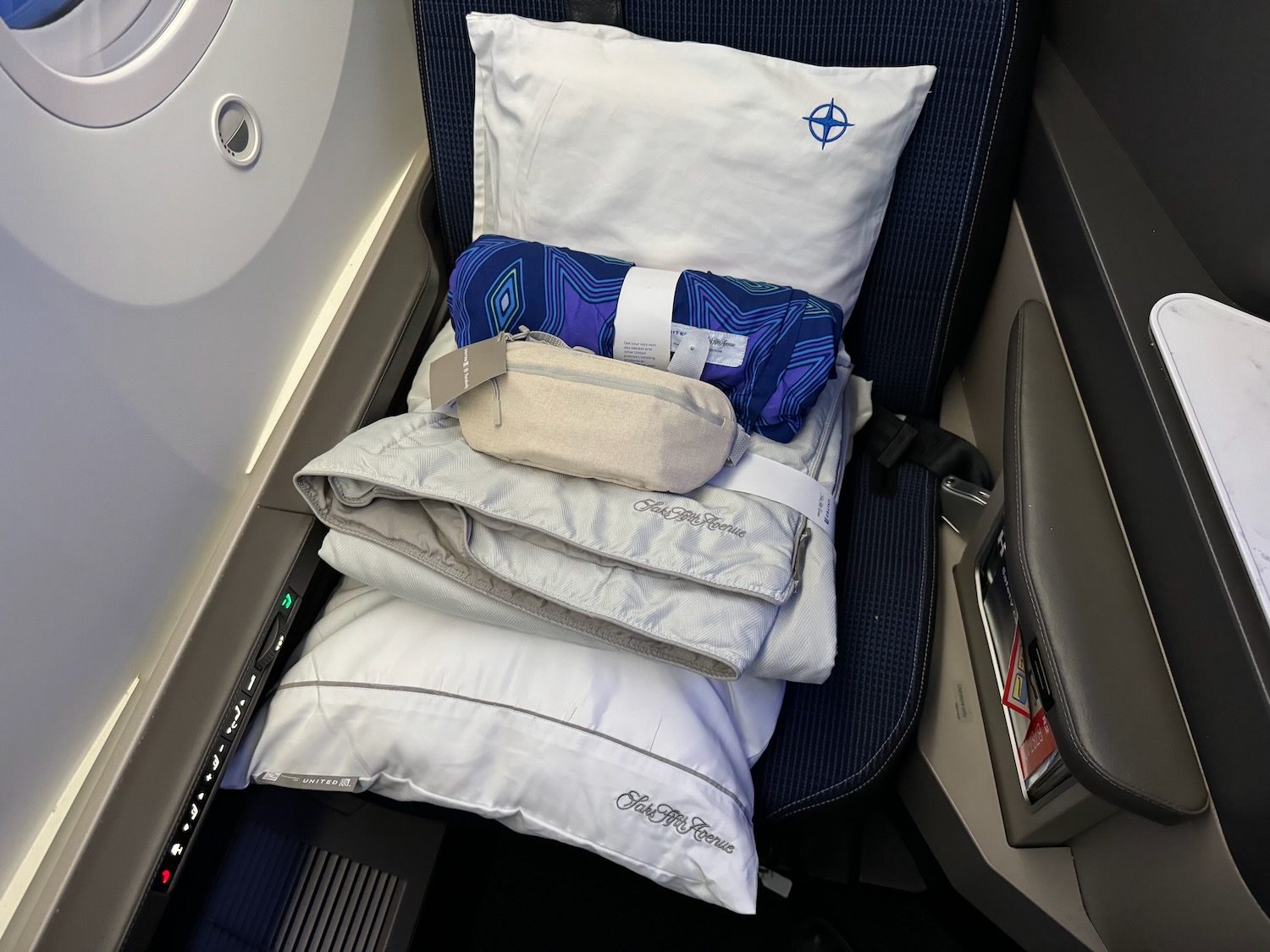 a pillow and blankets on a seat