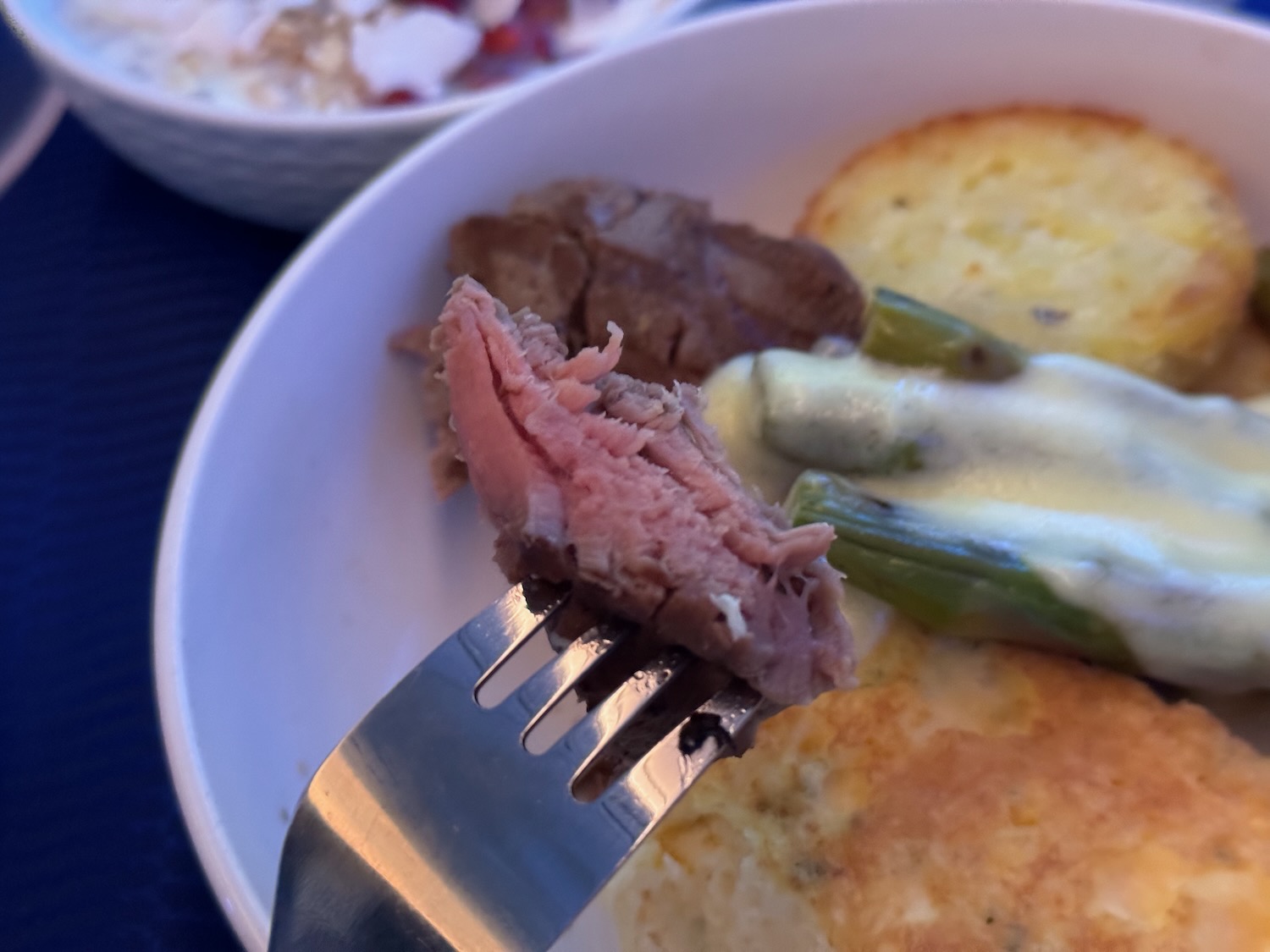 a fork on a fork with meat and vegetables in a bowl