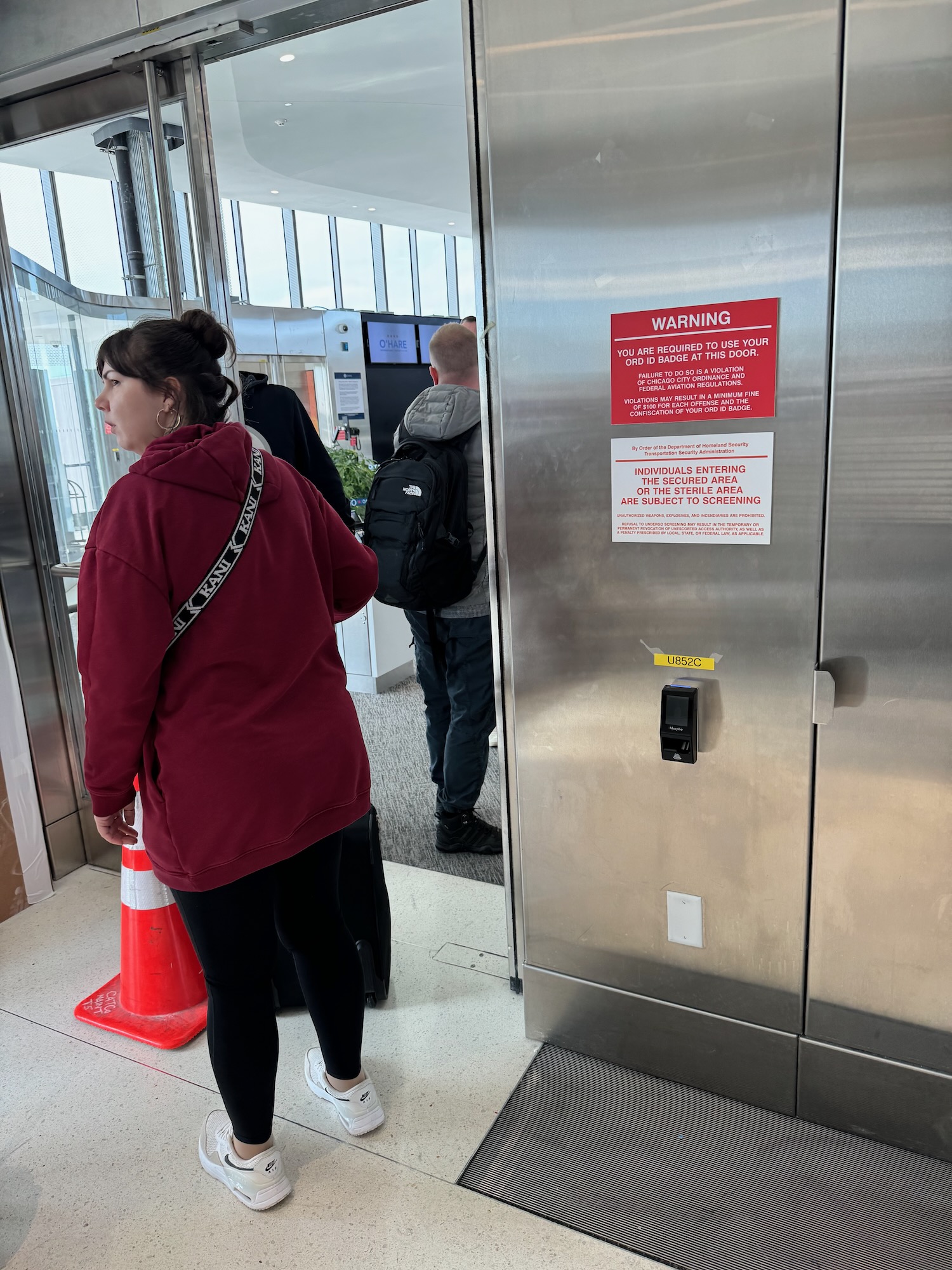 a woman standing in front of a metal elevator