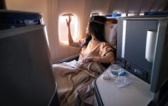 a woman in a bed looking out a window