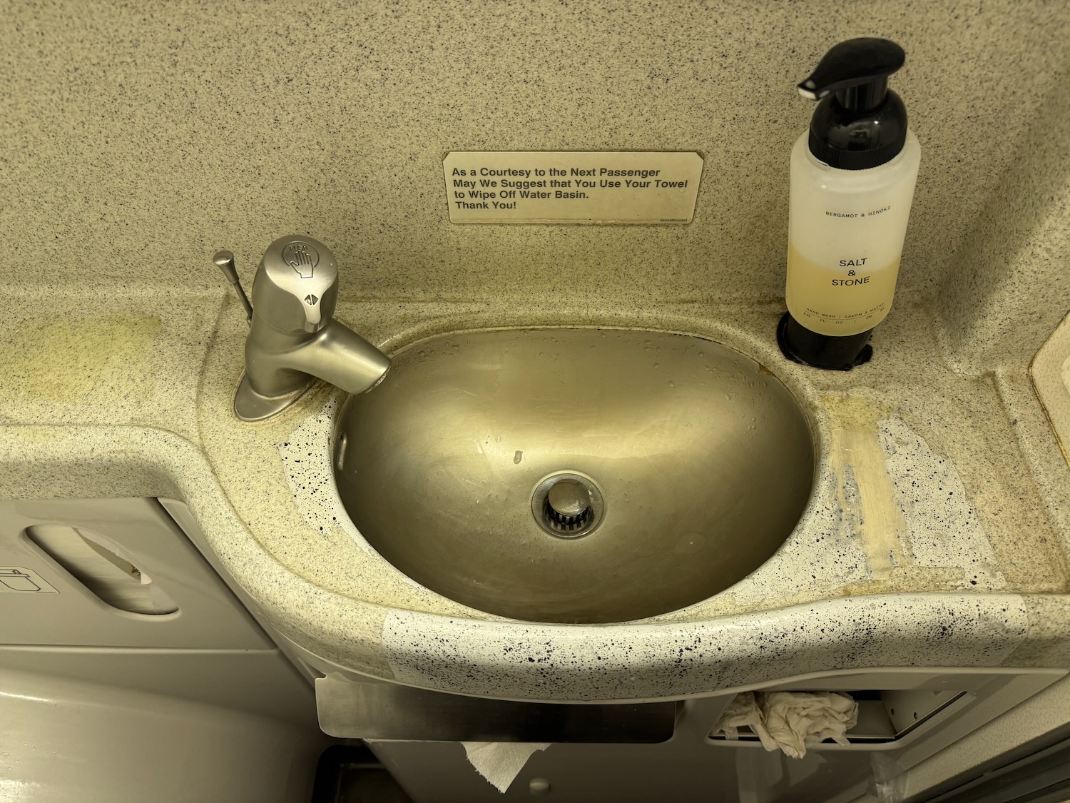 a sink with a soap dispenser and a bottle of liquid