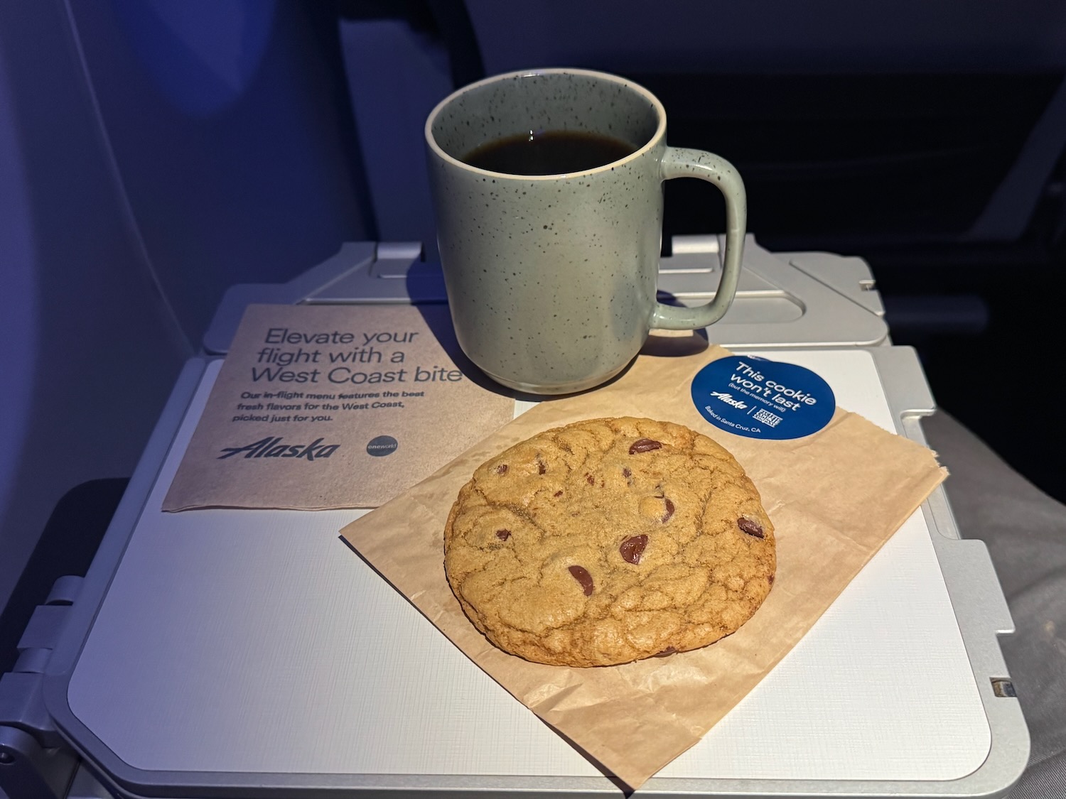 a cookie and a cup of coffee on a tray