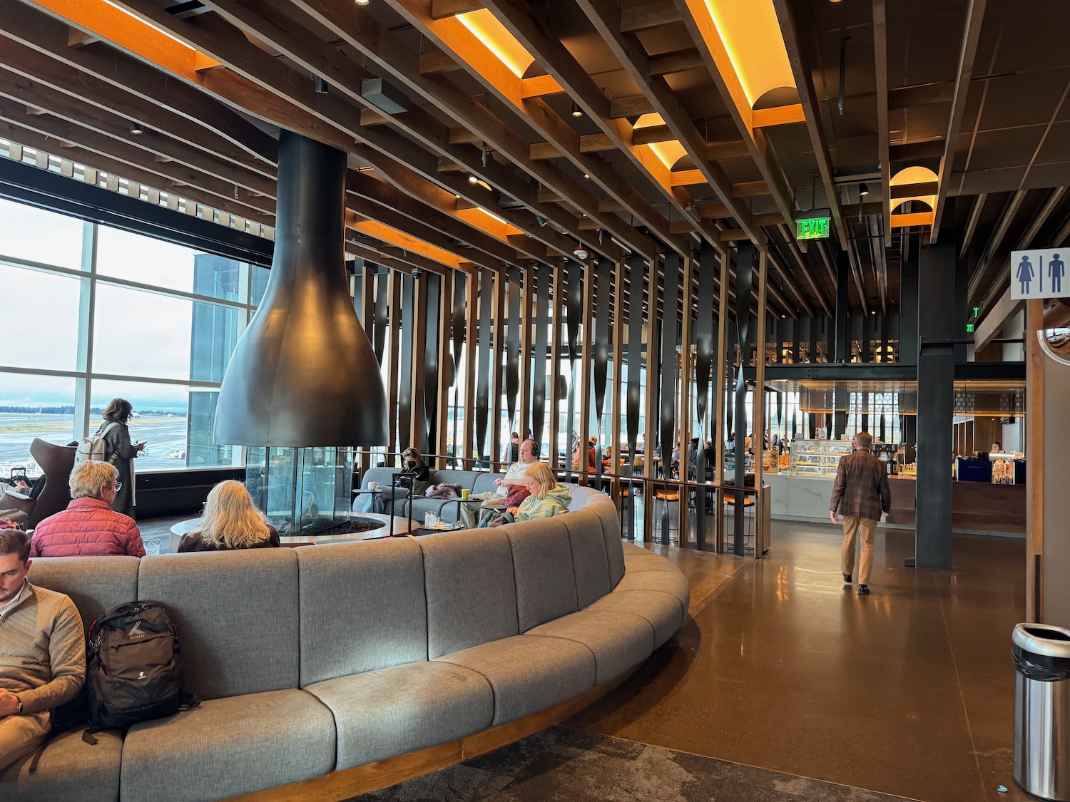 a group of people sitting on a couch in a room with a fireplace