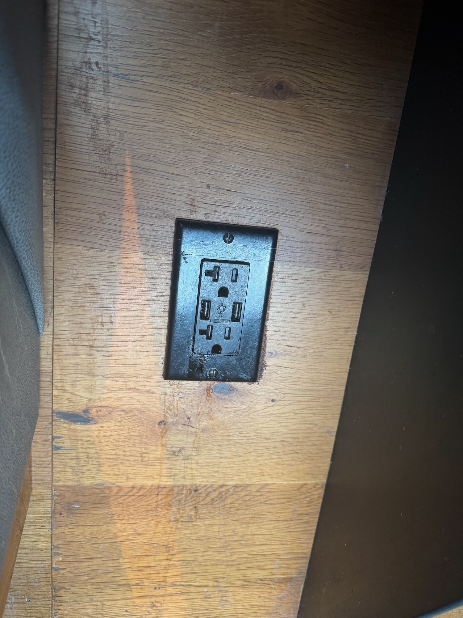 a black outlet on a wood surface