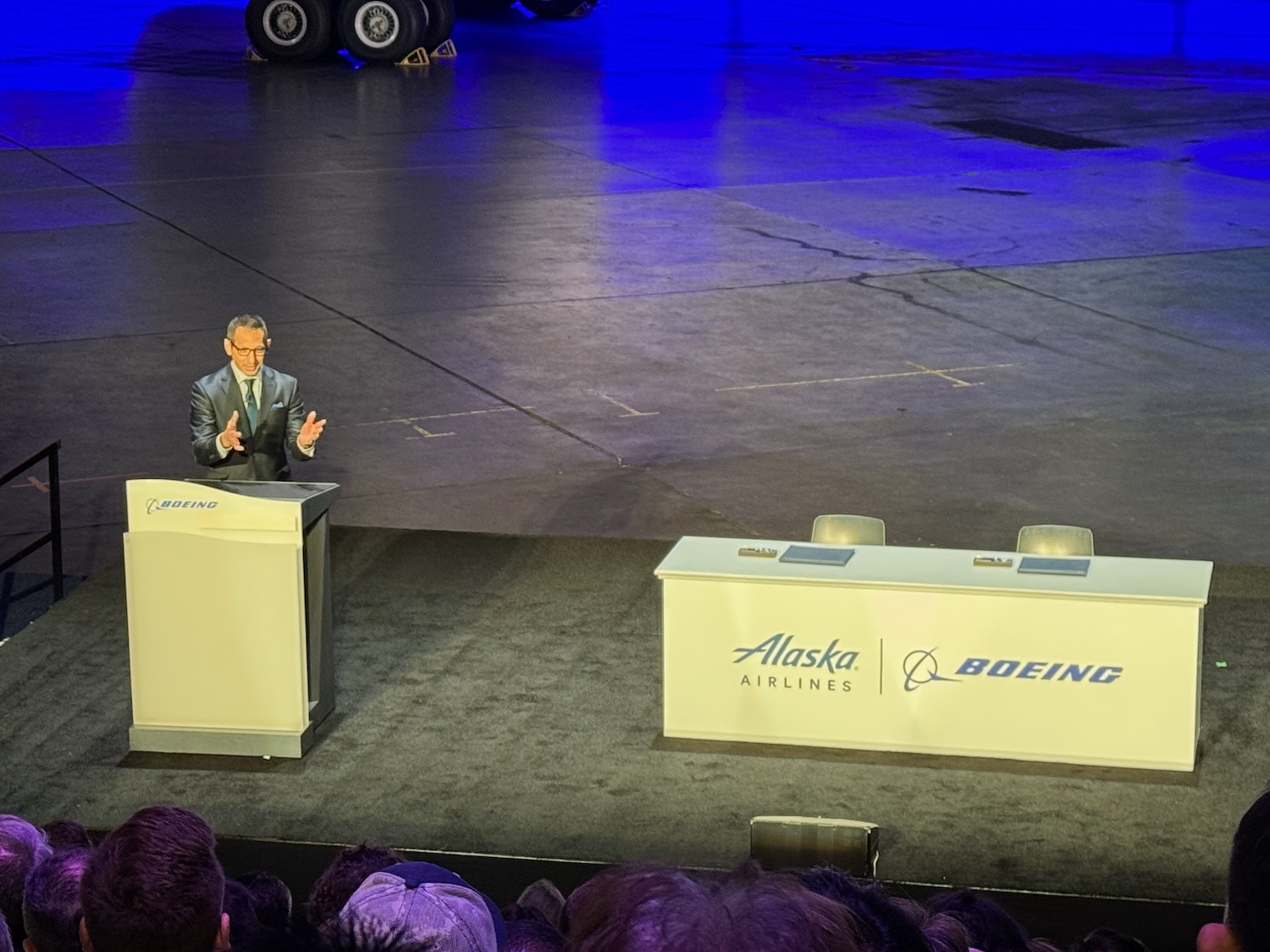 a man standing at podiums with a large crowd watching