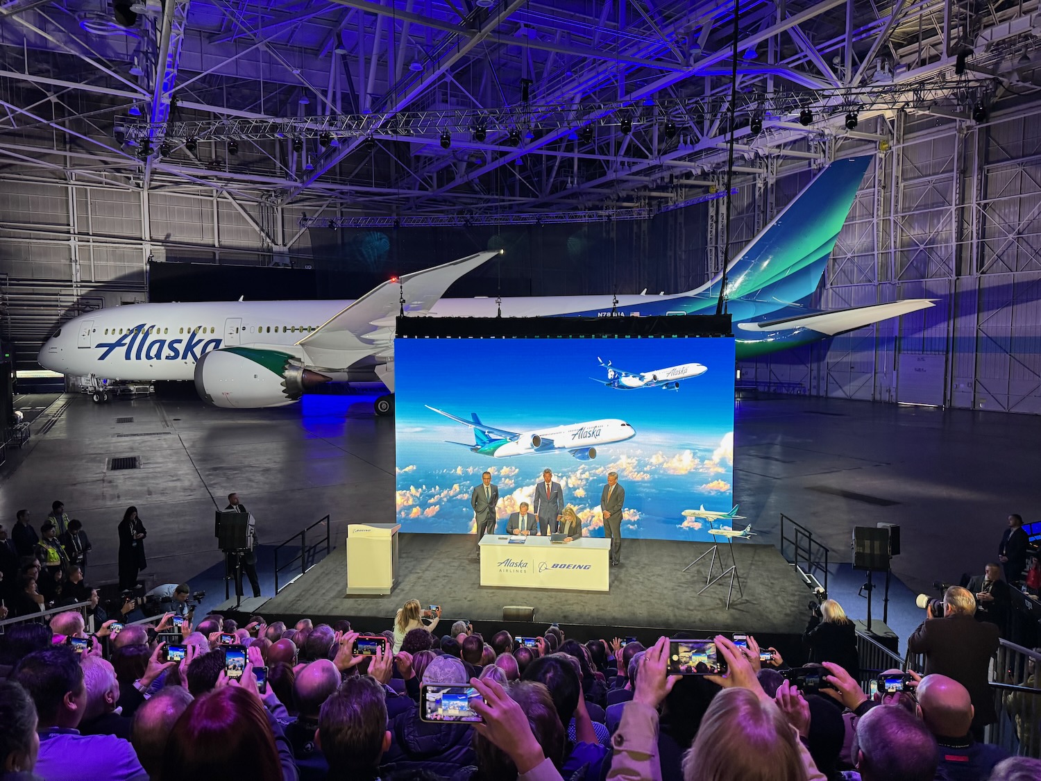 a group of people on a stage with an airplane in the background