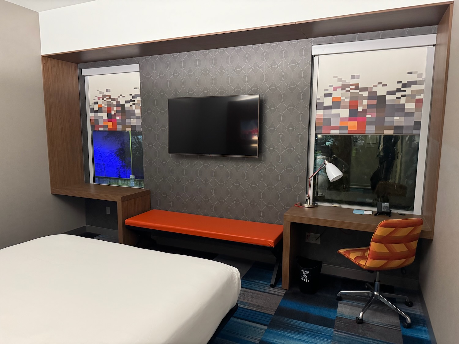 a room with a bed and a desk and a tv