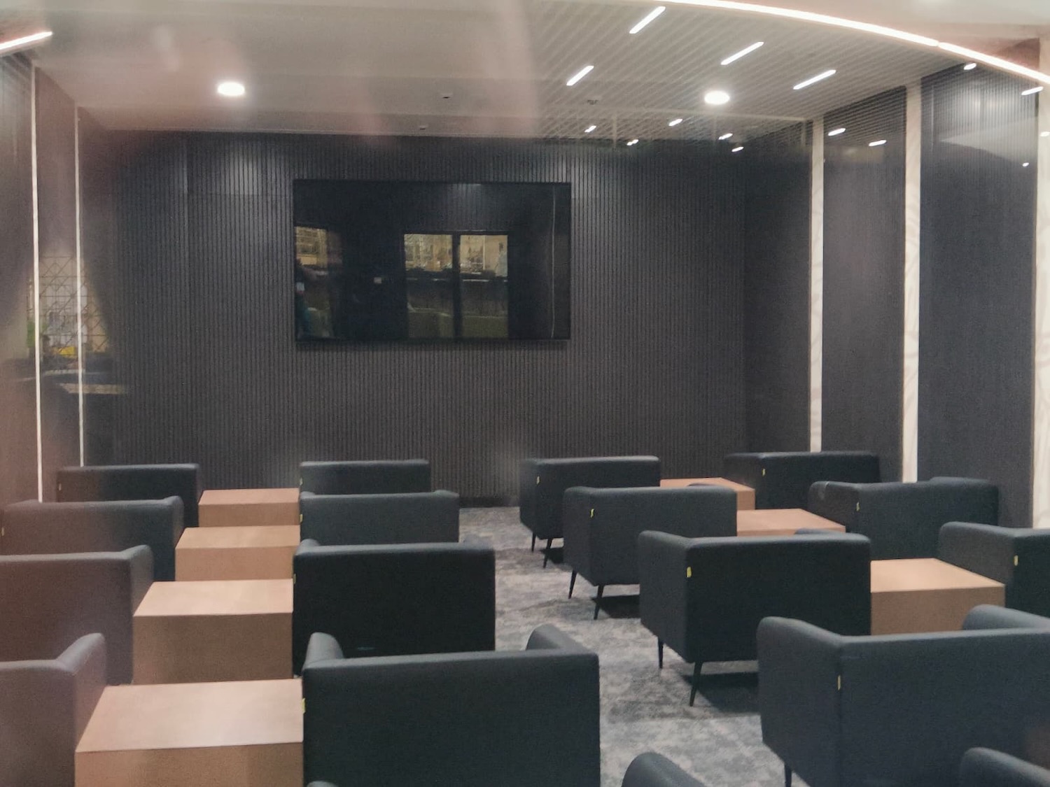 a room with black chairs and a television on the wall