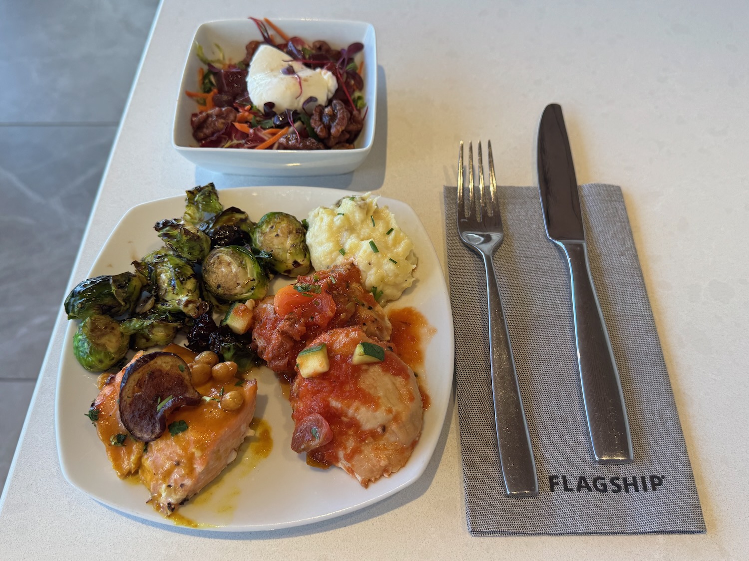 a plate of food with a bowl of salad and fork