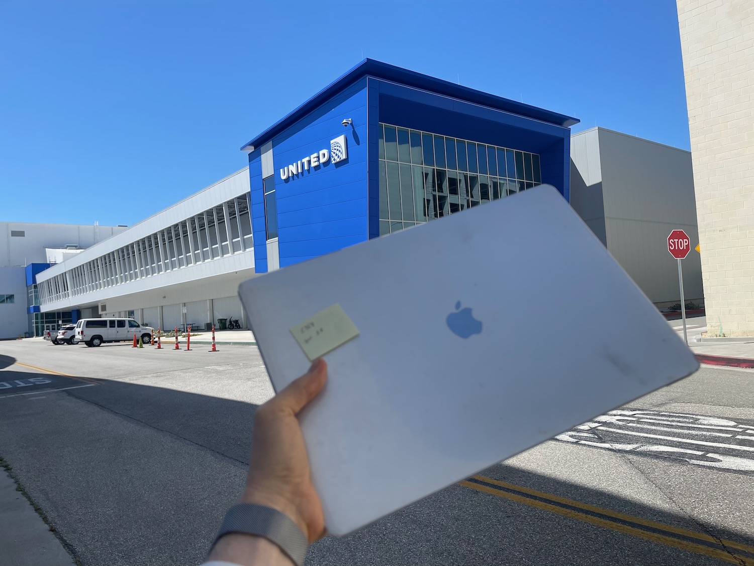 a hand holding a tablet in front of a building